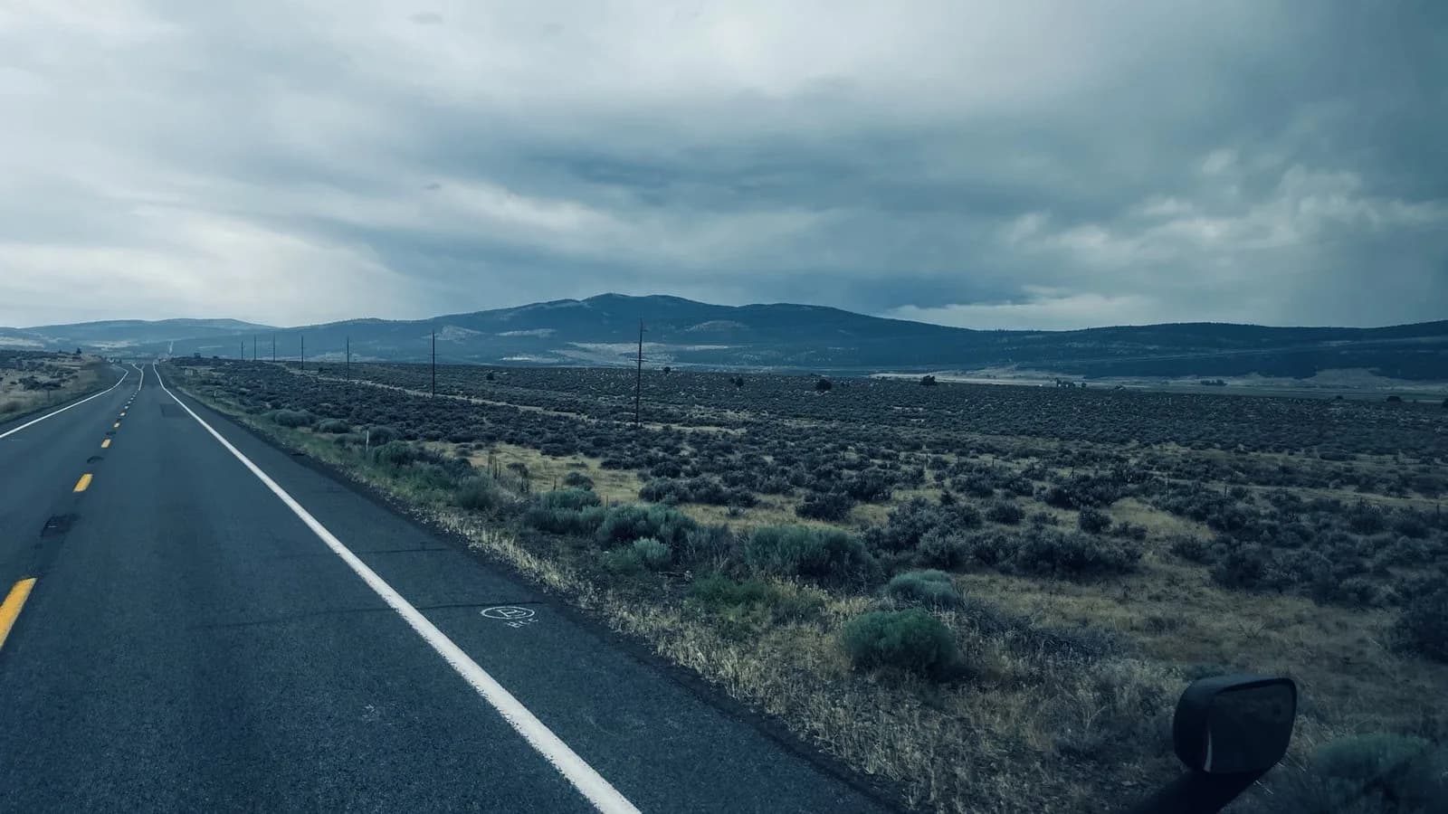 An open highway running toward distant hills